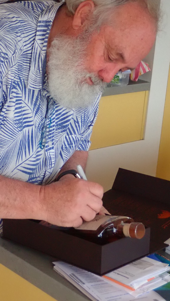 Bill signs a bottle of Lark whisky for Kathy Clay
